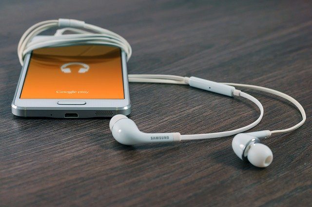 ipod with headphones wrapped around it laid on a table
